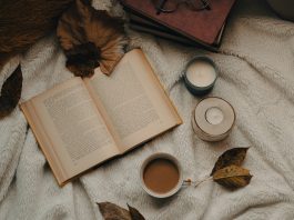 Lesestoff für goldene und graue Tage – die UnAufgefordert Buchtipps für den Herbst ein Buch liegt aufgeschlagen zwischen Laubblättern und Kerzen